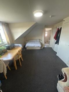 A spacious master bedroom with a cozy double be...