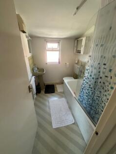 Bright and tidy bathroom featuring a bathtub wi...