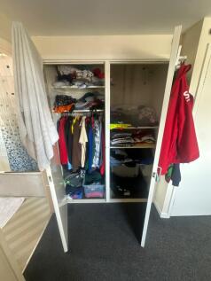 Well-organized storage closet with ample shelvi...