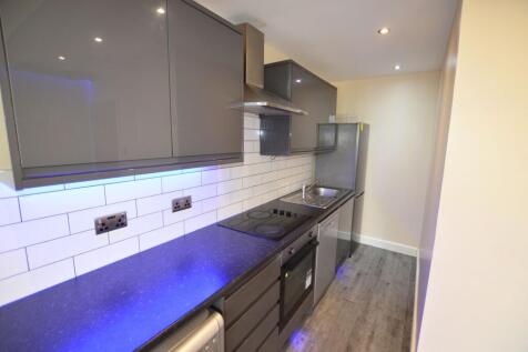 Modern and sleek kitchen featuring glossy cabin...