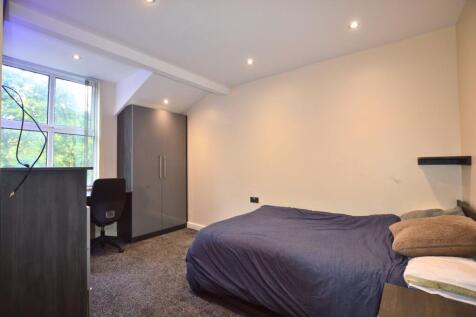 A neat and well-lit single bedroom featuring a ...