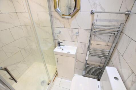 A modern bathroom featuring sleek marble-effect...