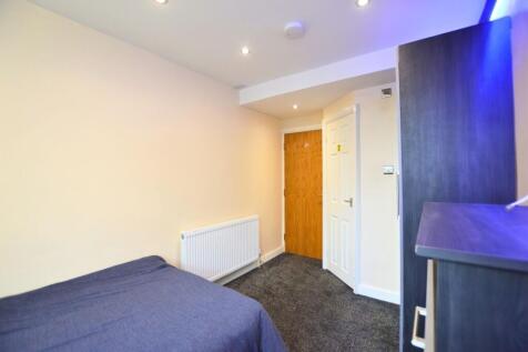 A cozy single bedroom featuring a neatly made b...