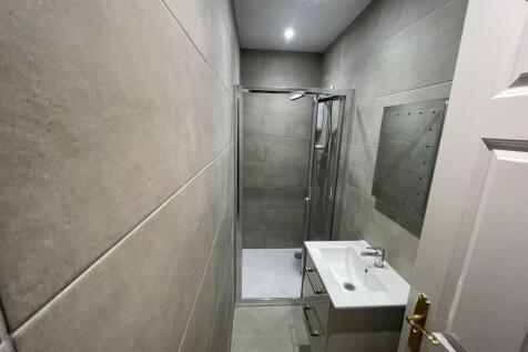 Modern bathroom featuring a walk-in shower with...