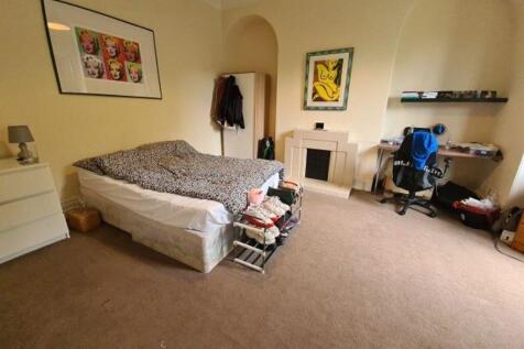 A spacious double bedroom featuring a comfortab...