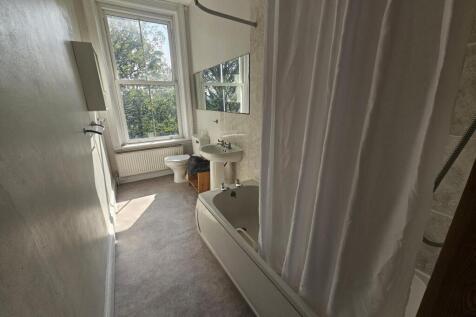 A well-maintained bathroom featuring a bathtub ...