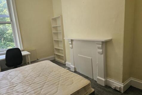 A cozy bedroom featuring a large window that al...