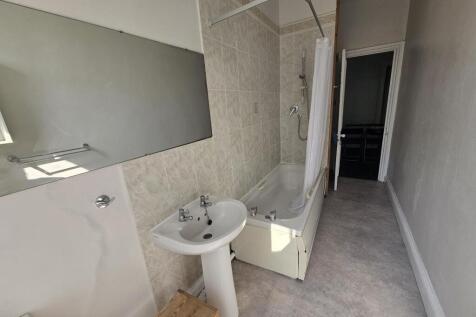A well-maintained bathroom featuring a bathtub ...