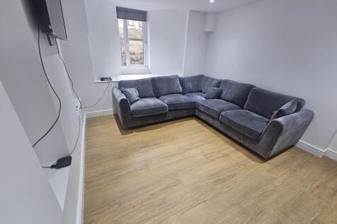 A bright and spacious living room featuring a c...