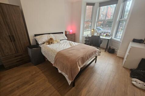 A spacious and well-lit master bedroom featurin...