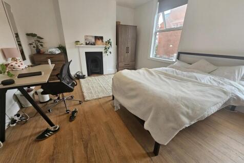 A well-maintained bedroom featuring a large bed...