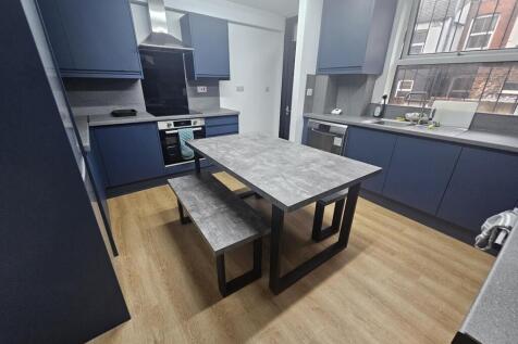 A modern kitchen with ample blue cabinetry, a r...