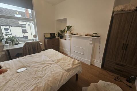 A cozy bedroom with a large window allowing nat...