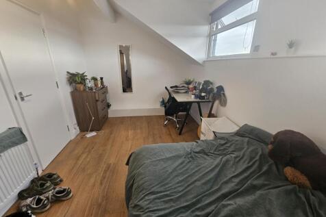 A cozy bedroom with a neatly made bed, natural ...