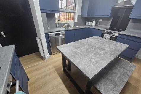 A modern kitchen with blue cabinetry and a larg...