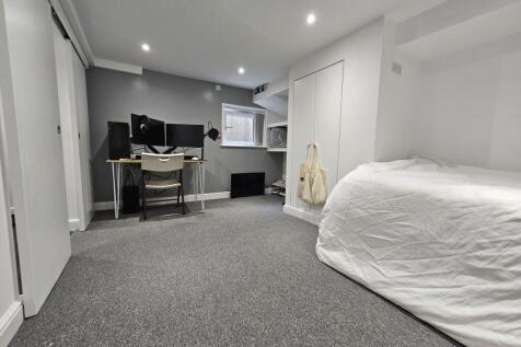 A tidy and well-lit bedroom featuring a large b...