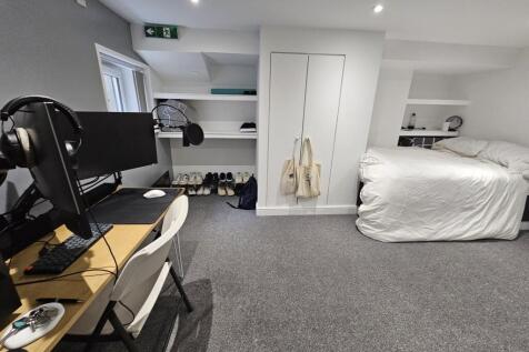 A bright and clean bedroom featuring a comforta...