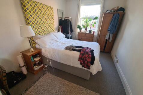 A cozy bedroom featuring a double bed with cris...