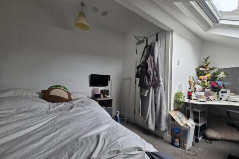 A cozy bedroom with a large bed, illuminated by...