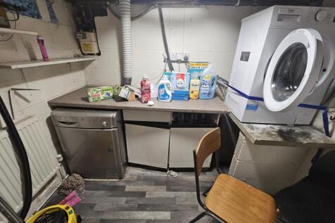 A compact kitchen area featuring a washing mach...