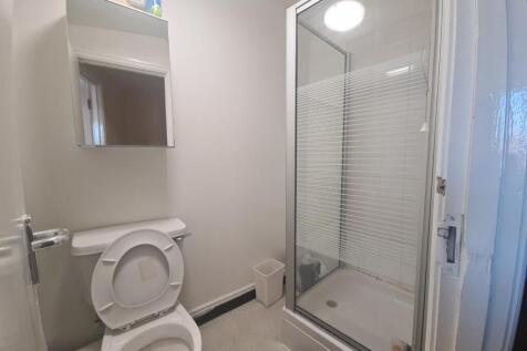 A clean, modern bathroom with a glass-enclosed ...