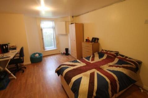 A cozy single bedroom featuring a bed with a Un...