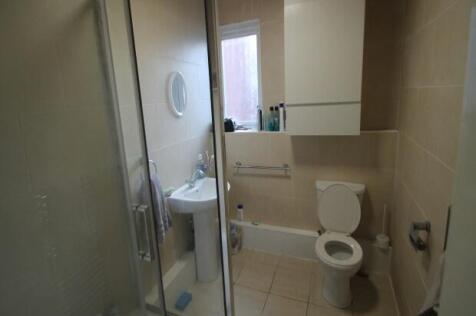 A modern bathroom with a toilet, sink, and show...