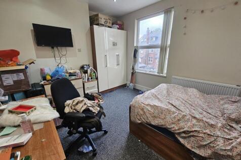 A cozy bedroom featuring a bed covered with a p...