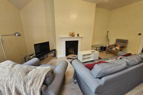 A spacious, well-lit living room featuring comf...