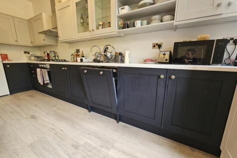 A modern kitchen with white upper cabinets and ...