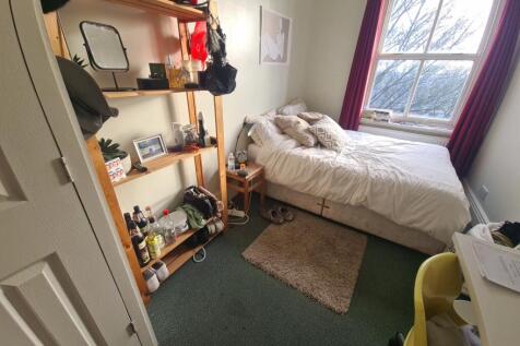 A cozy bedroom featuring a double bed near a wi...