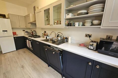 Modern kitchen with a sleek white countertop, a...