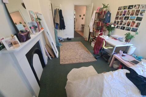 A cozy bedroom with a bed, personal belongings,...