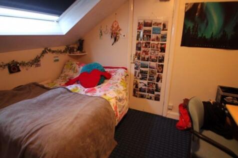 Cozy bedroom featuring a comfortable bed, brigh...