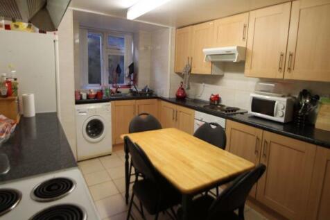 A well-lit kitchen with wooden cabinets and a s...