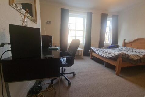 A bright and inviting bedroom featuring a woode...