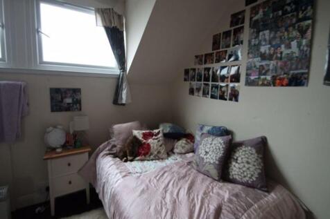 A cozy bedroom featuring a comfortable bed with...