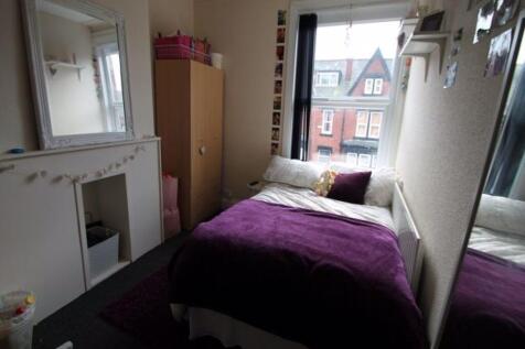 A cozy bedroom featuring a single bed with a pu...