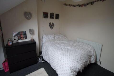 A cozy and tidy bedroom featuring a neatly made...