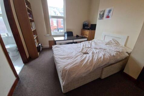 A bright and tidy bedroom featuring a double be...