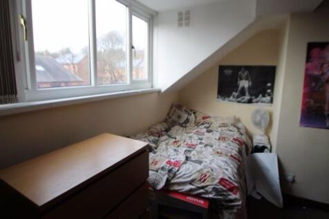 A cozy single bedroom featuring a neatly made b...