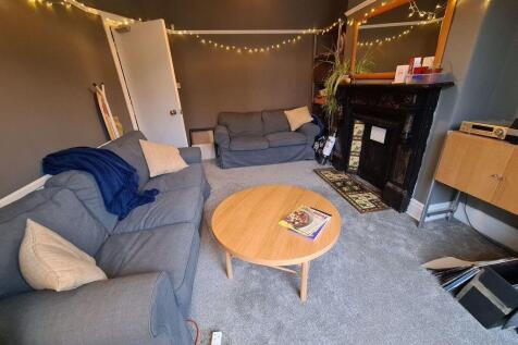 A modern, well-lit living room featuring a comf...