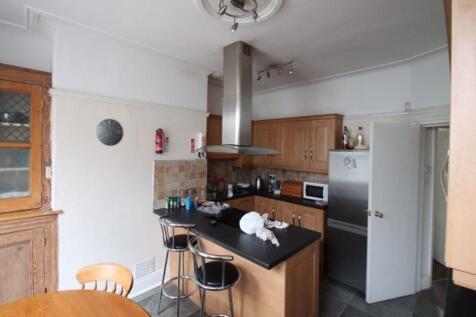 A modern kitchen with a black countertop, stain...