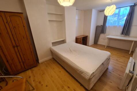 A bright and tidy bedroom featuring a comfortab...