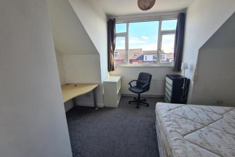 A cozy and well-maintained bedroom with a large...