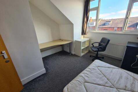 A bright and tidy bedroom featuring a comfortab...