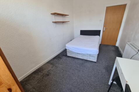 A simple, well-maintained bedroom featuring a s...