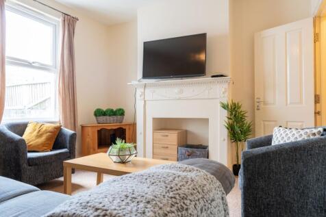 Bright, neatly furnished living room with comfo...