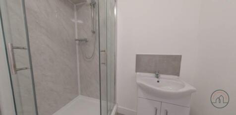 Modern ensuite-style bathroom with a corner gla...