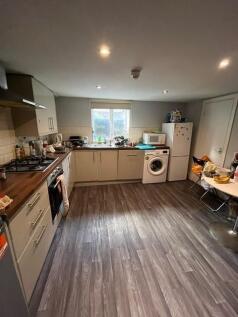 Modern fitted kitchen with light cabinetry, int...